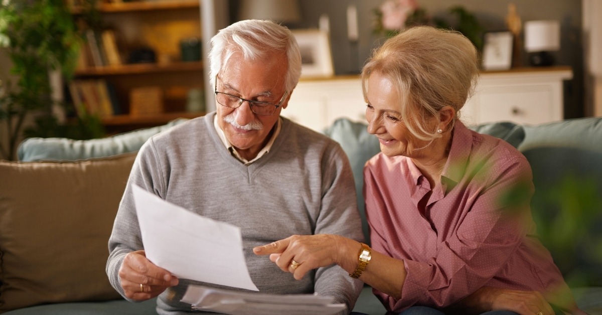 Happy older couple with paperwork