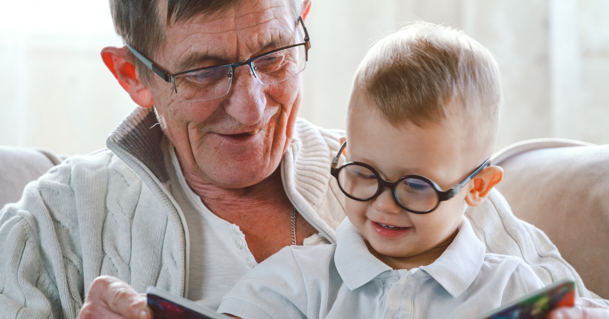 Grandfather and grandson are reading a book