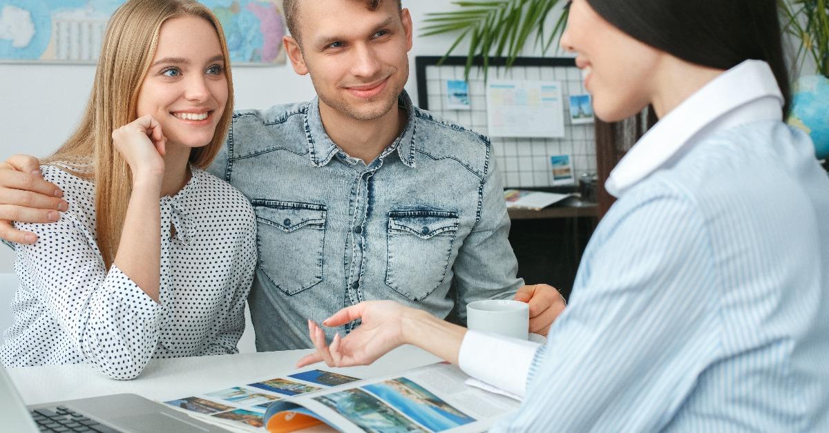 Young couple in a tour agency with a travel agent