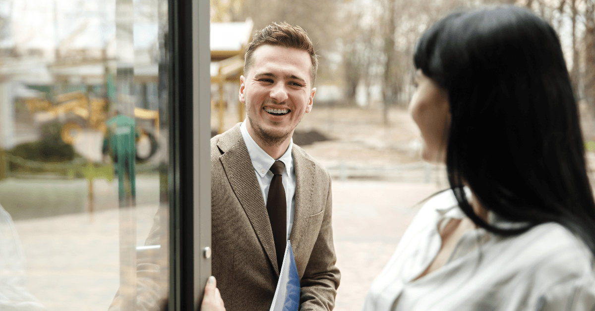 Woman holding door for coworker