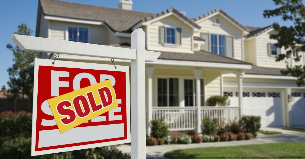 Sold home for sale sign and house