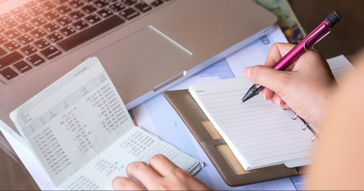 man taking notes with account passbook  