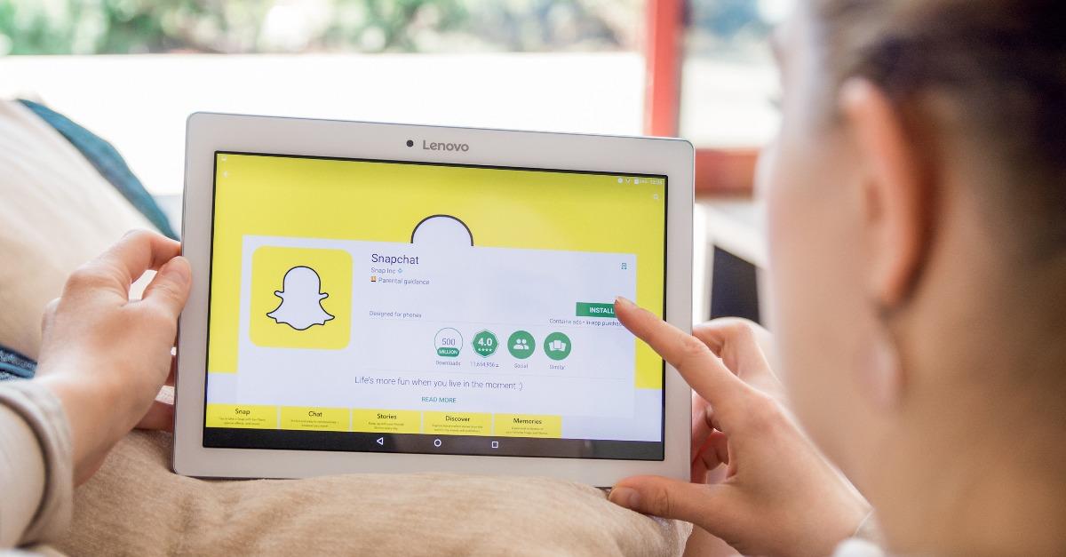 Woman is installing Snapchat application on Lenovo tablet