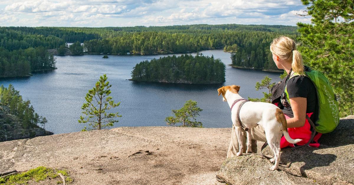 woman hiking with dog in National Park in Finland