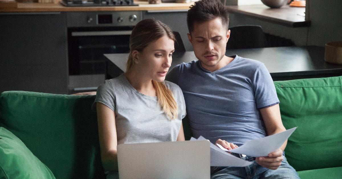 worried couple confused reading bad news in bank loan documents