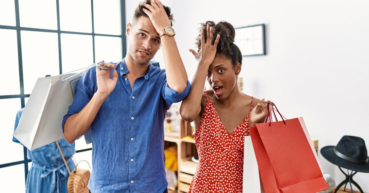 Young interracial couple holding shopping bags at retail shop