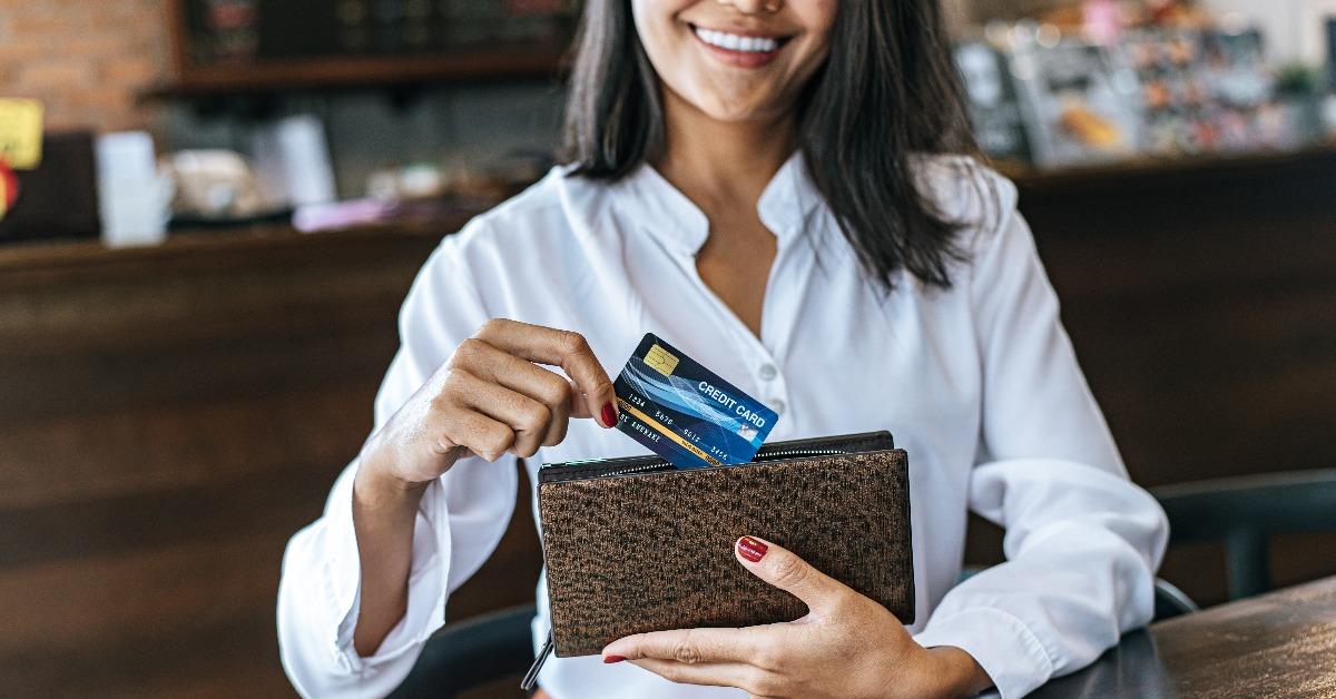 accepting credit cards from a brown purse to pay for goods on coffee orders