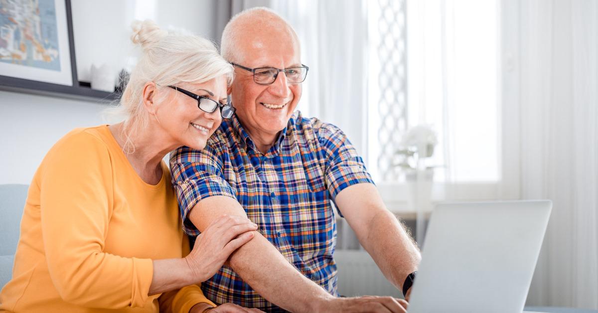 senior couple checking bills using laptop