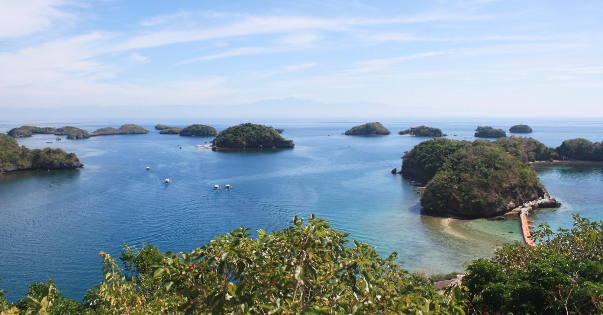boats sailing across group of islets small islands in beautiful blue waters and clear sky