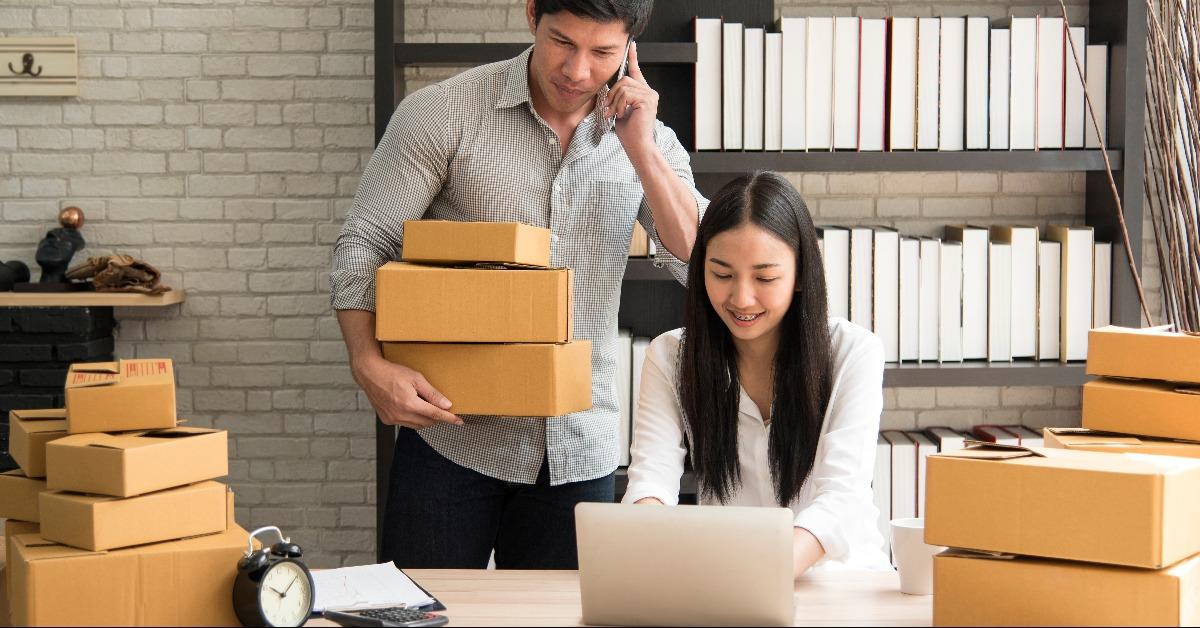 asian couple with boxes and laptop