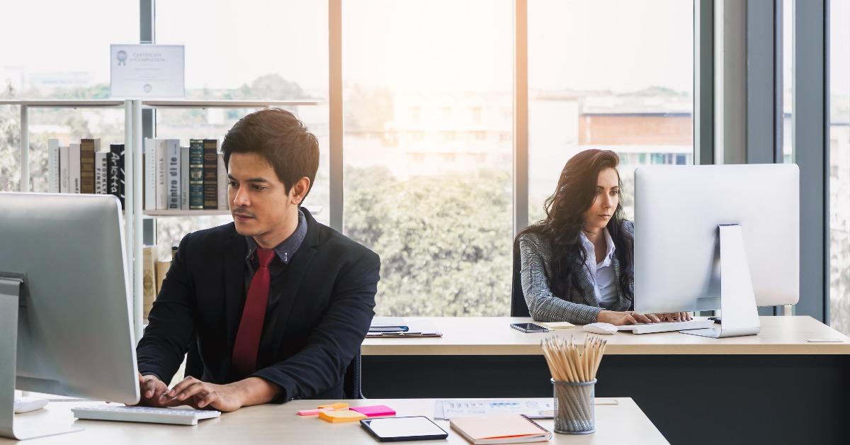 asian businessman and caucasian business woman using computers in modern office