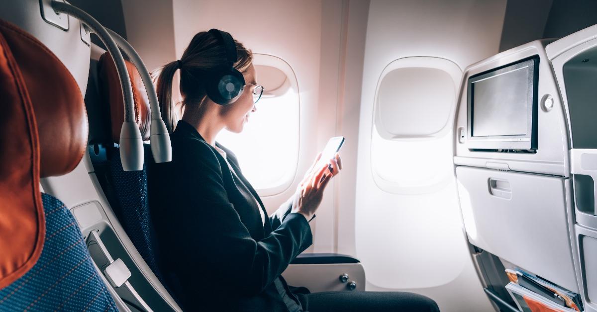 caucasian female airplane passenger reading received email via mobile phone