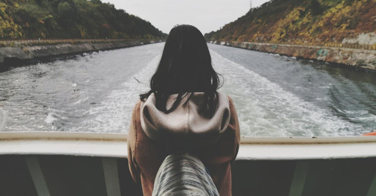 back of a woman centered on a river
