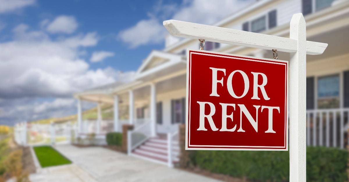 for rent real estate sign in front of house
