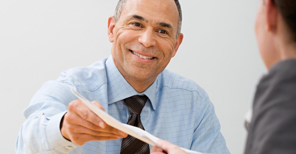 businessman passing file to colleague