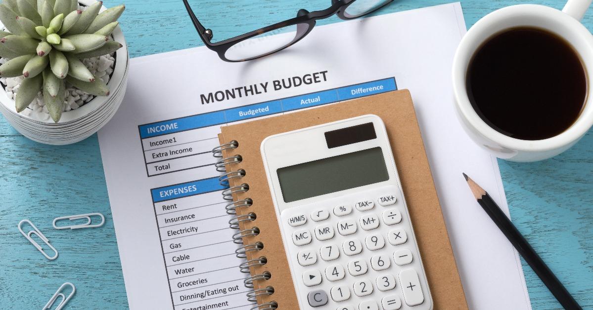 monthly budget with white calculator on blue table