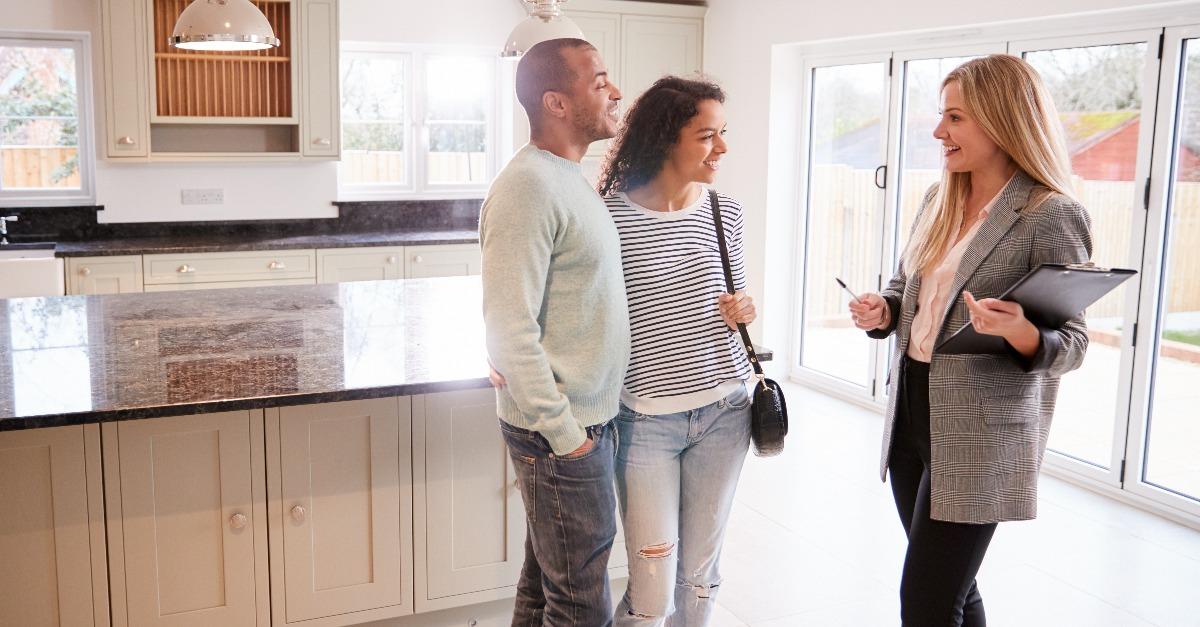 female realtor showing couple interested in buying around house