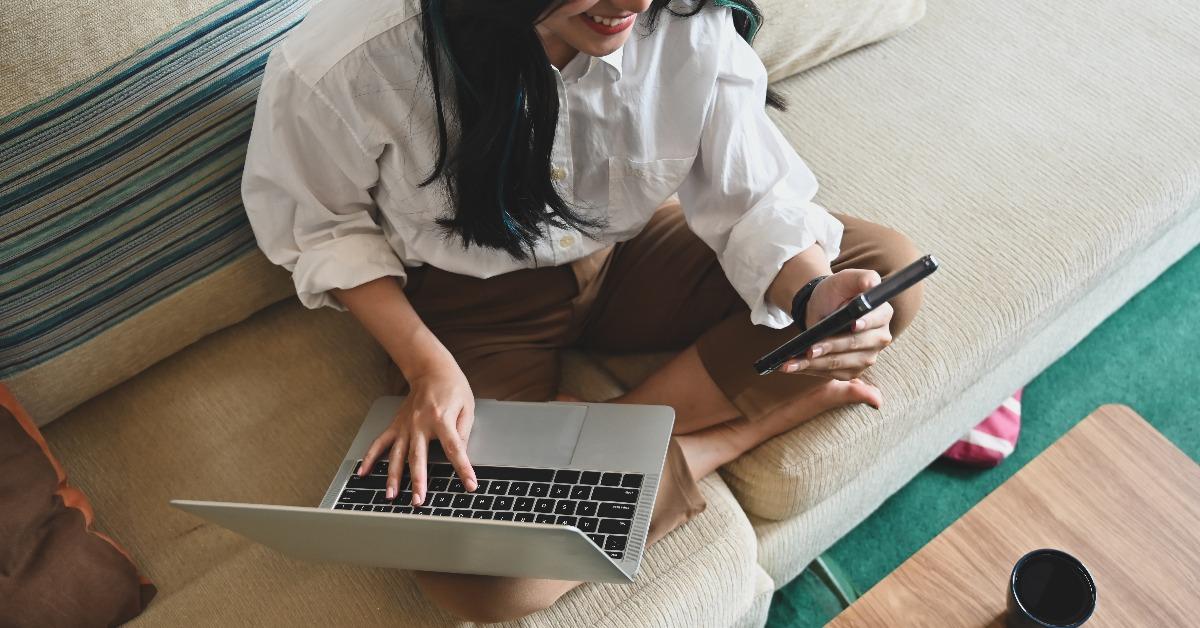  young relaxing beautiful woman sitting on the sofa while typing on the keyboard
