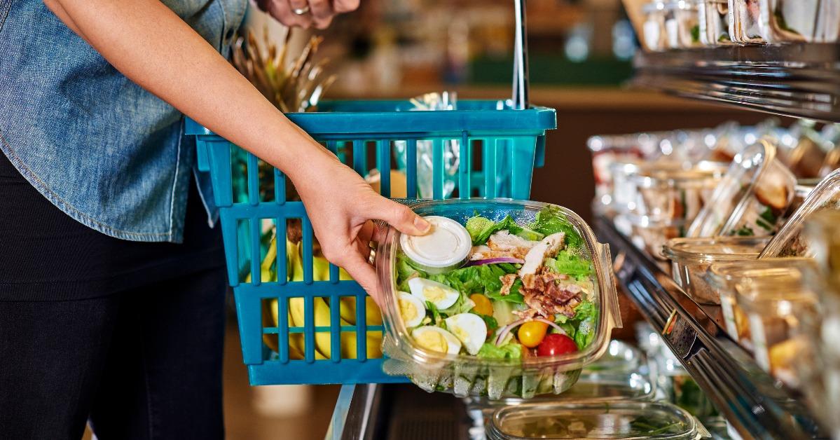 a woman buying a salad at a deli