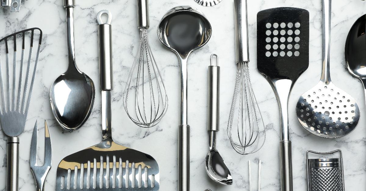 different kitchen utensils on marble background