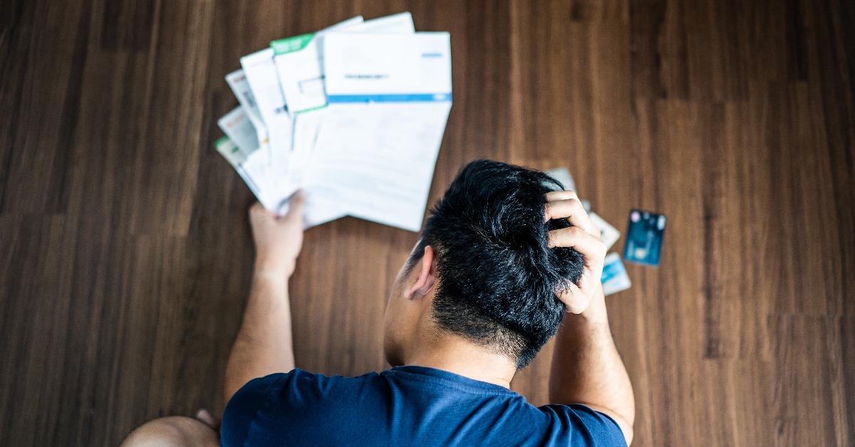 stressed young Asian man hands holding the head trying to find money to pay credit card