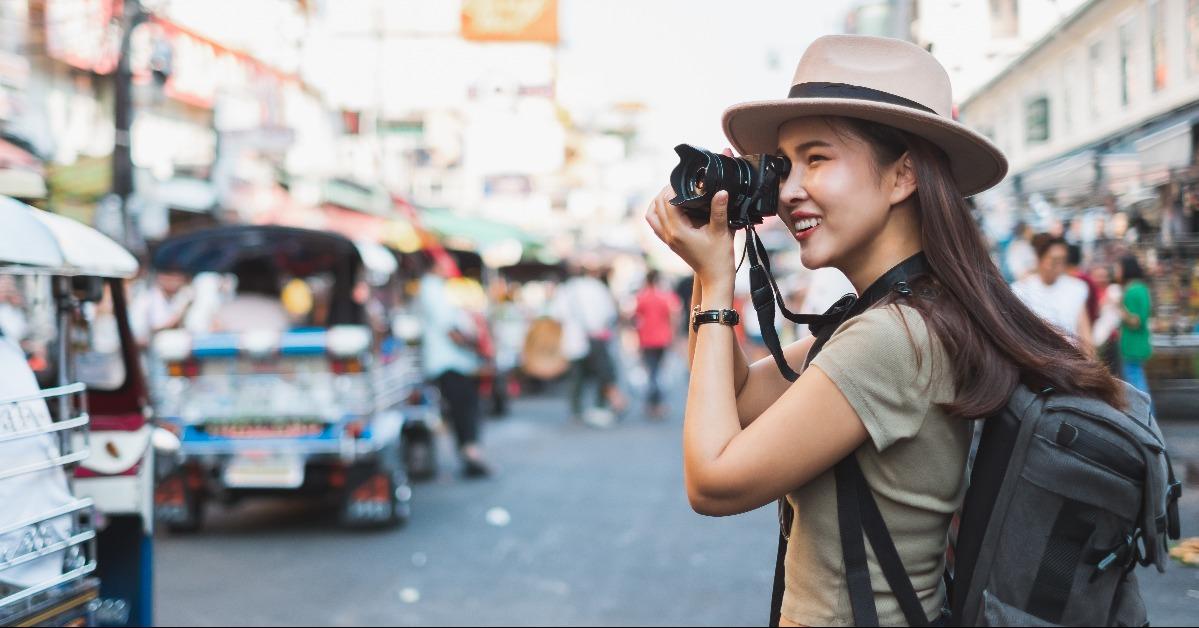 Asian woman tourist backpacker travel and taking photo in Khao San road Bangkok Thailand