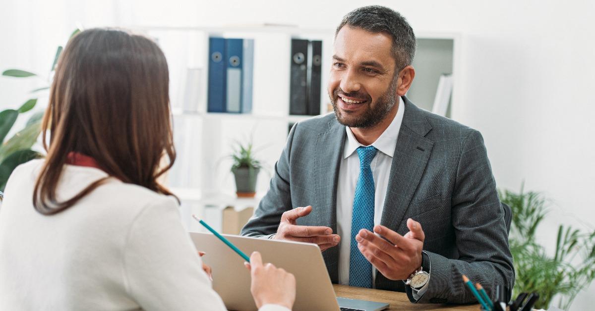 advisor sitting at table with laptop and woman in office