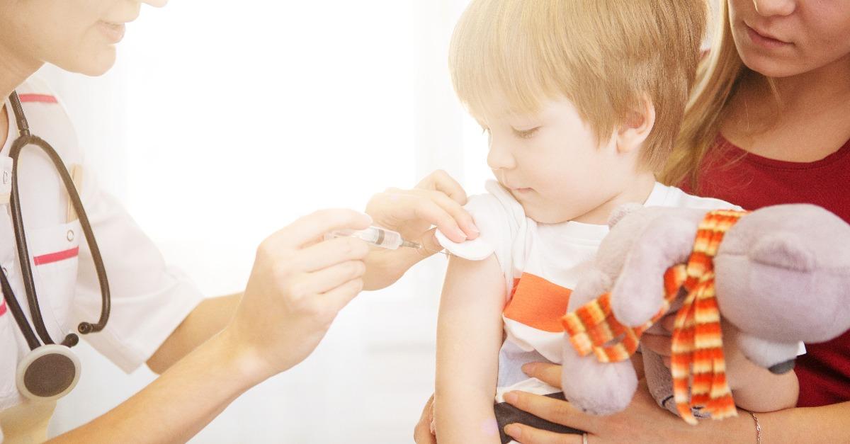 a doctor giving a child an injection at home
