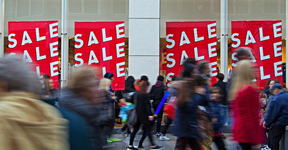 People walking past sale signs