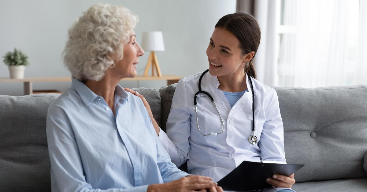 caring young woman nurse supporting a senior patient