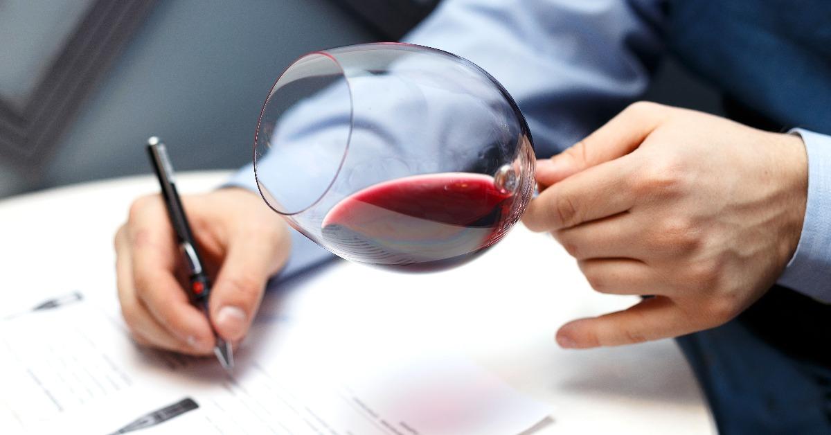 male sommelier is checking and testing red wine