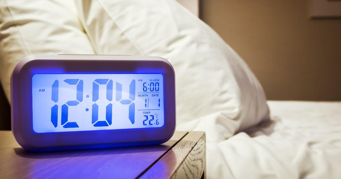 electronic alarm clock stands on a bedside table