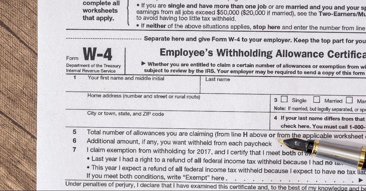 w 4 tax form with pen on desk