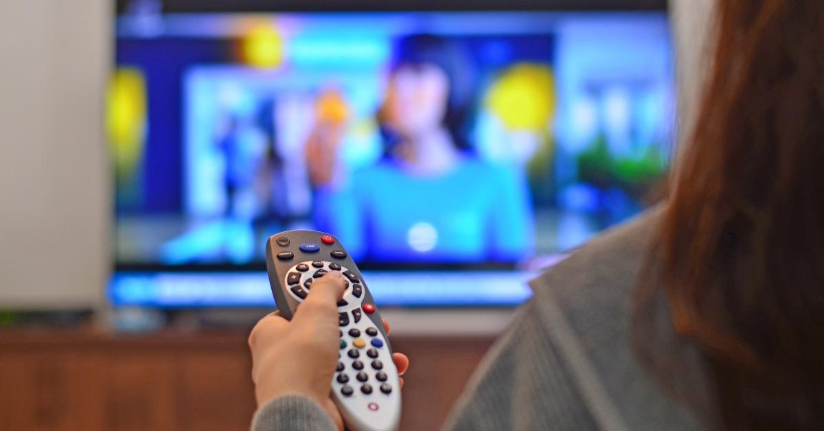 woman watching tv and using remote controller