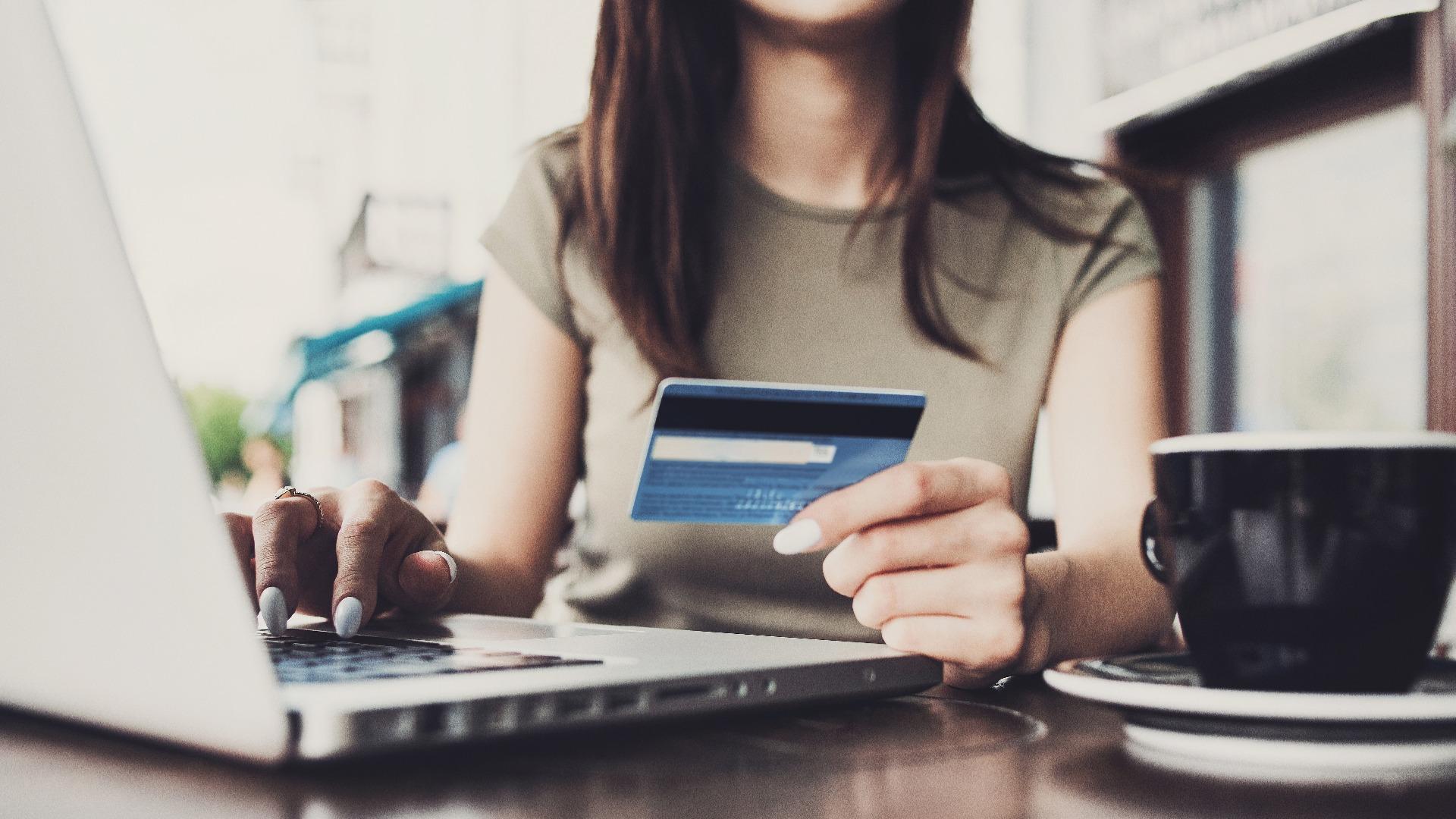 holding credit card and using laptop computer