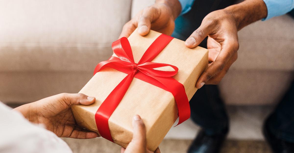 Father hands giving birthday gift to daughter