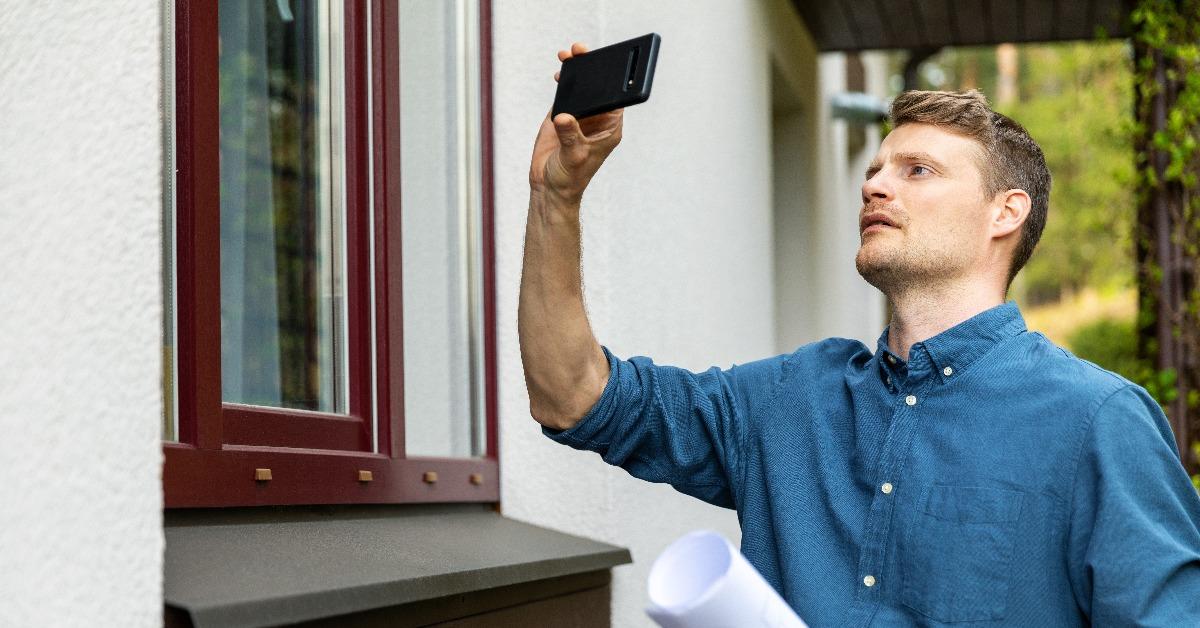 real estate appraiser taking pictures of property with phone