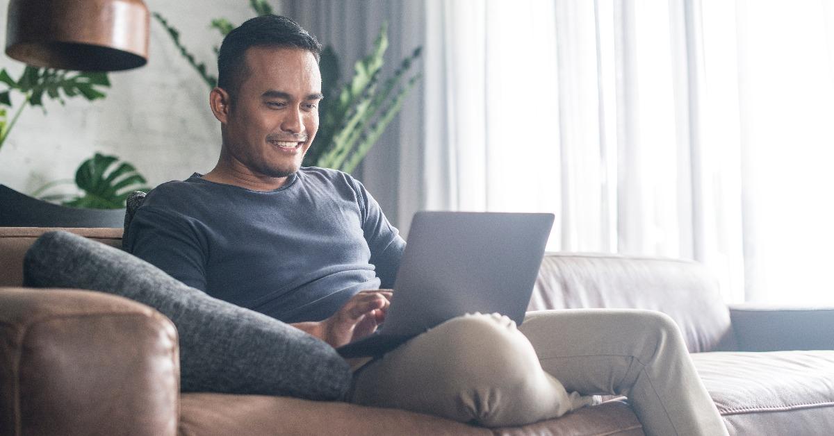 Asian man looking at the computer at home