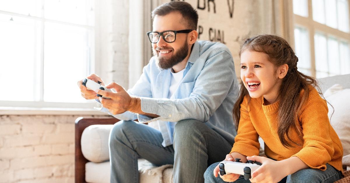 father and daughter laughing and playing video games
