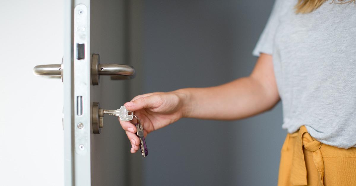 Woman hands opening a door with keys