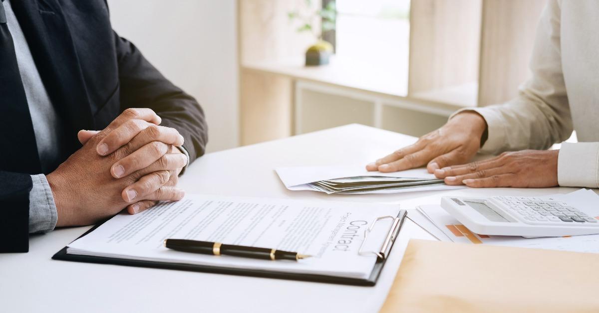 businessman giving money in the envelope while making deal to agreement