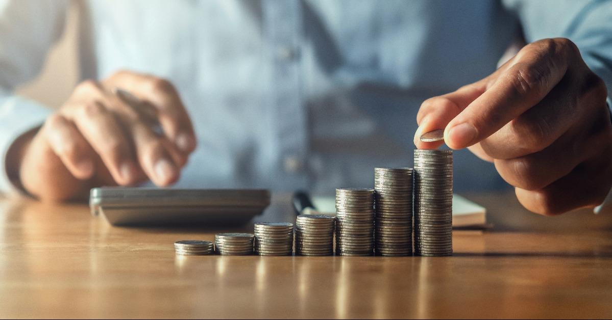 saving money with hand putting coins on stack