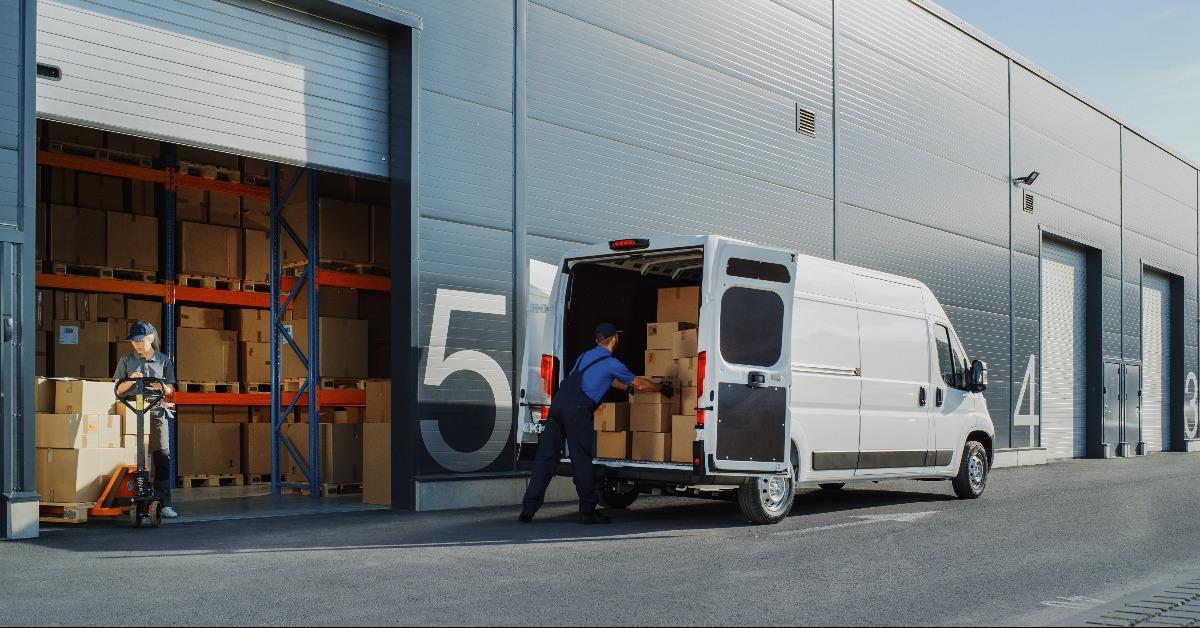 worker loading delivery truck with cardboard boxes