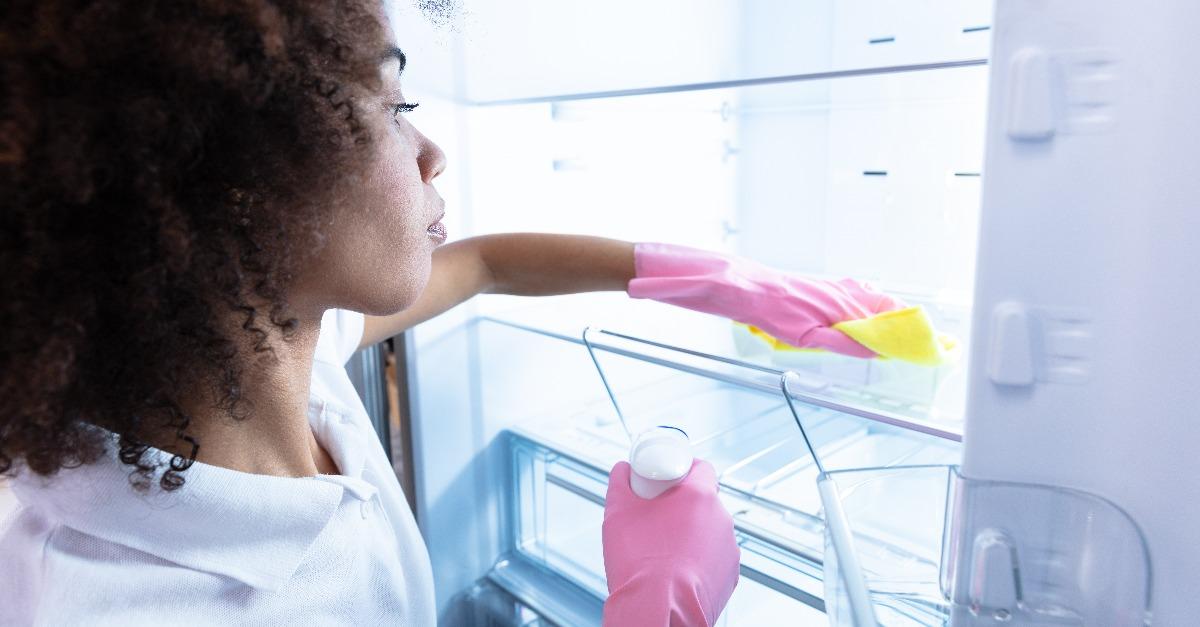 woman wearing gloves cleaning refrigerator