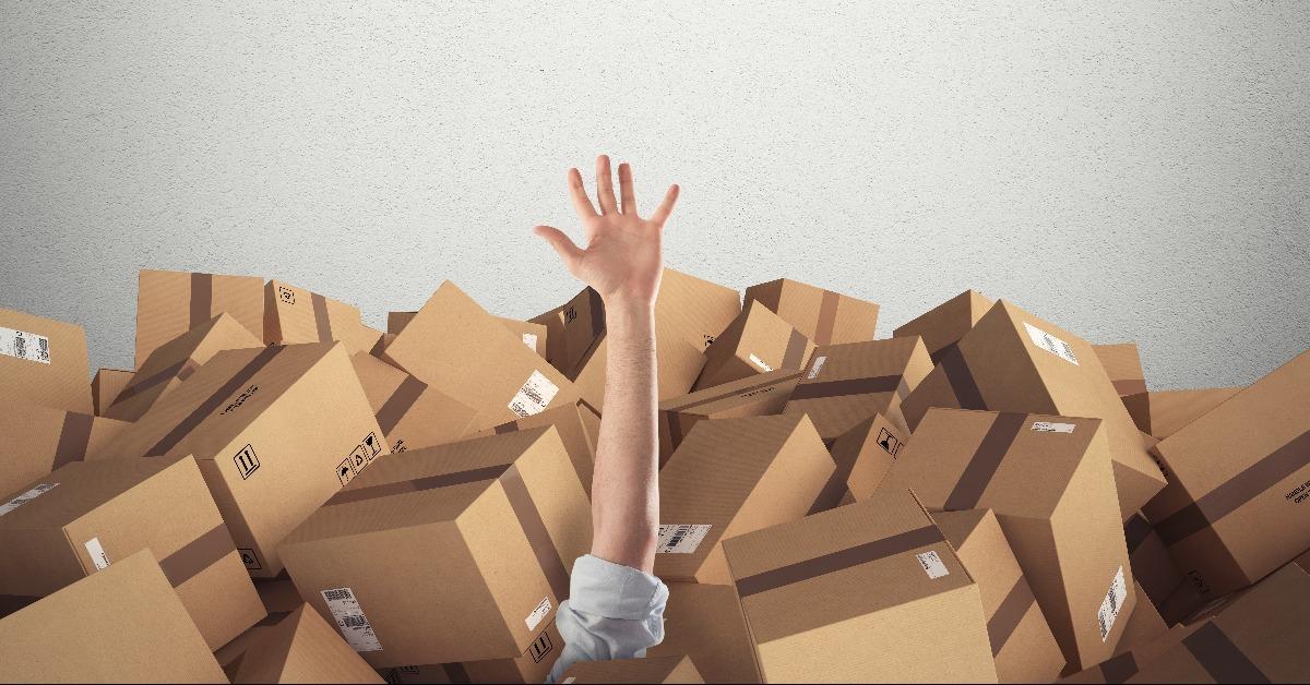 man buried by a stack of cardboard boxes