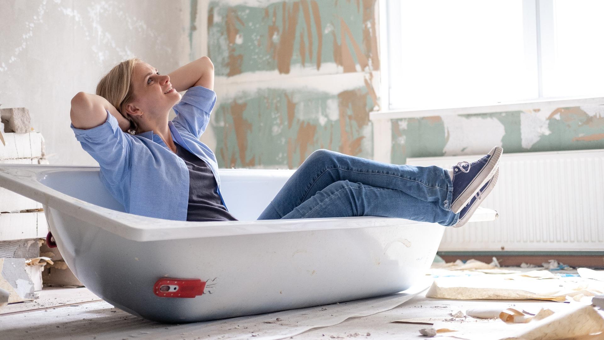 woman sits in bathtub in the middle of the room
