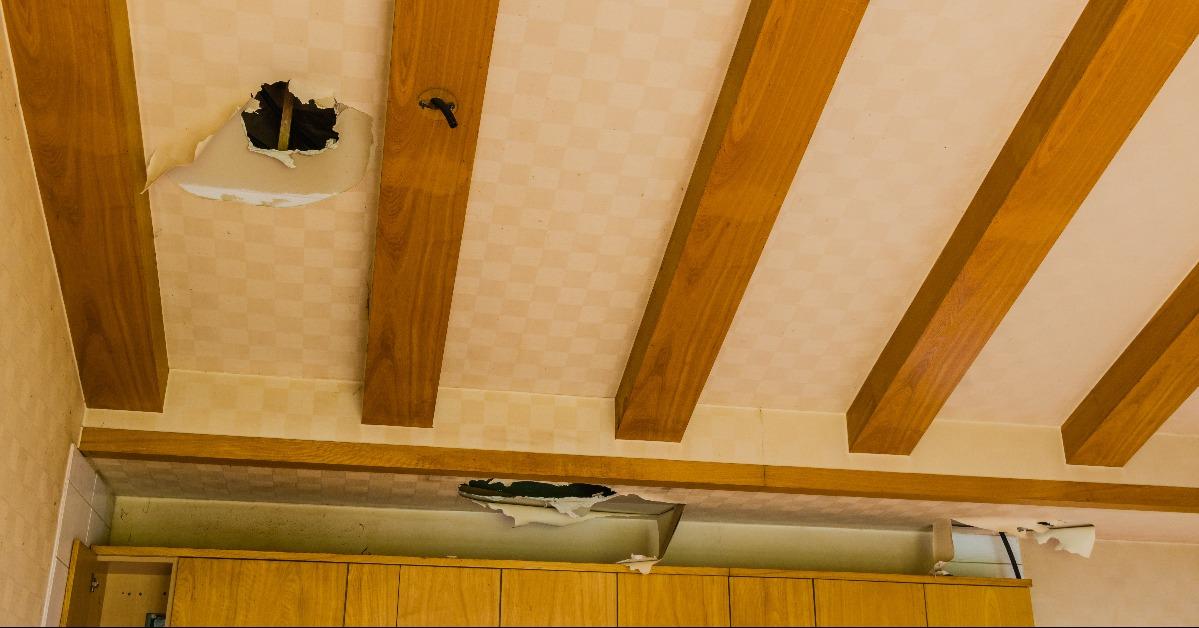 Holes and torn wallpaper in ceiling