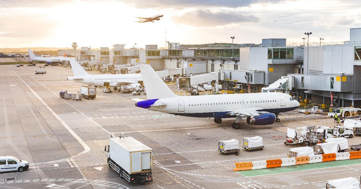 Busy airport view with airplanes and service vehicles at sunset
