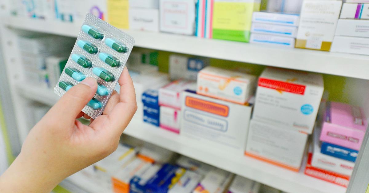 hand holding medicine capsule pack at the pharmacy drugstore