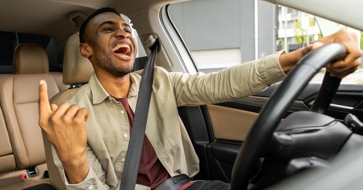 man dancing in car singing while driving his car